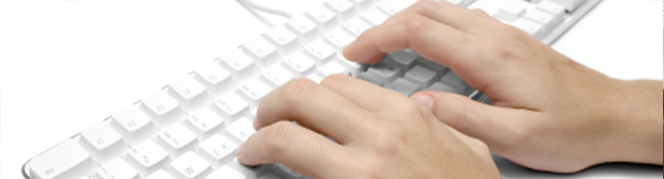 Duas mãos digitando num teclado de cor branca.